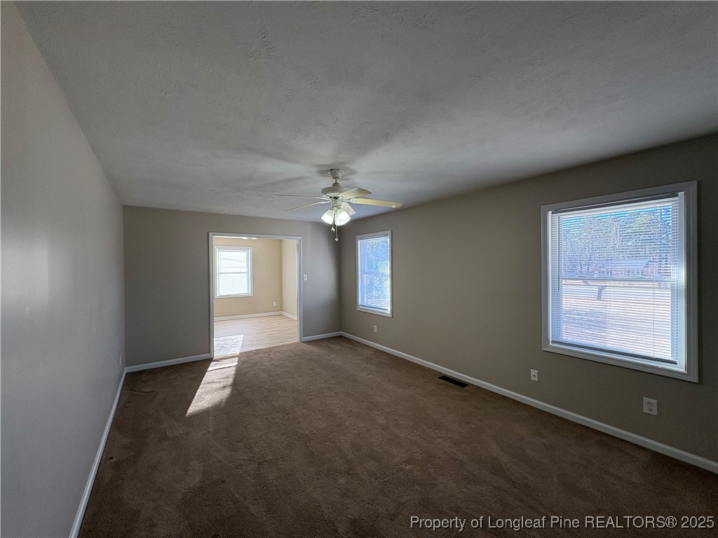 4639 Legion Road Hope Mills, NC 28348 - Photo 4 of 35 an empty room with windows and chandelier fan