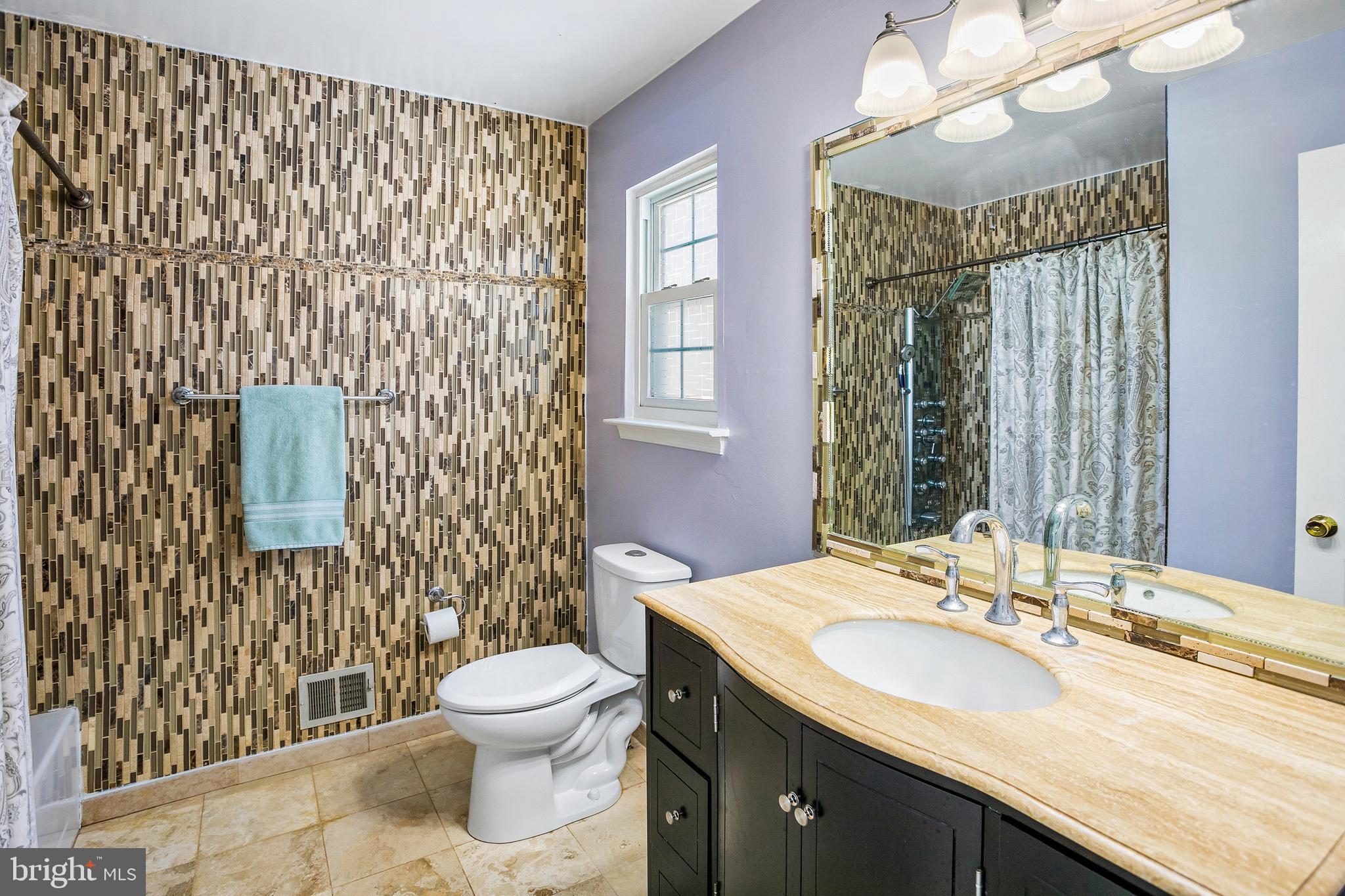 8217 Bayberry Ridge Road Fairfax Station, VA 22039 - Photo 20 of 35 a bathroom with a granite countertop sink a toilet and a mirror