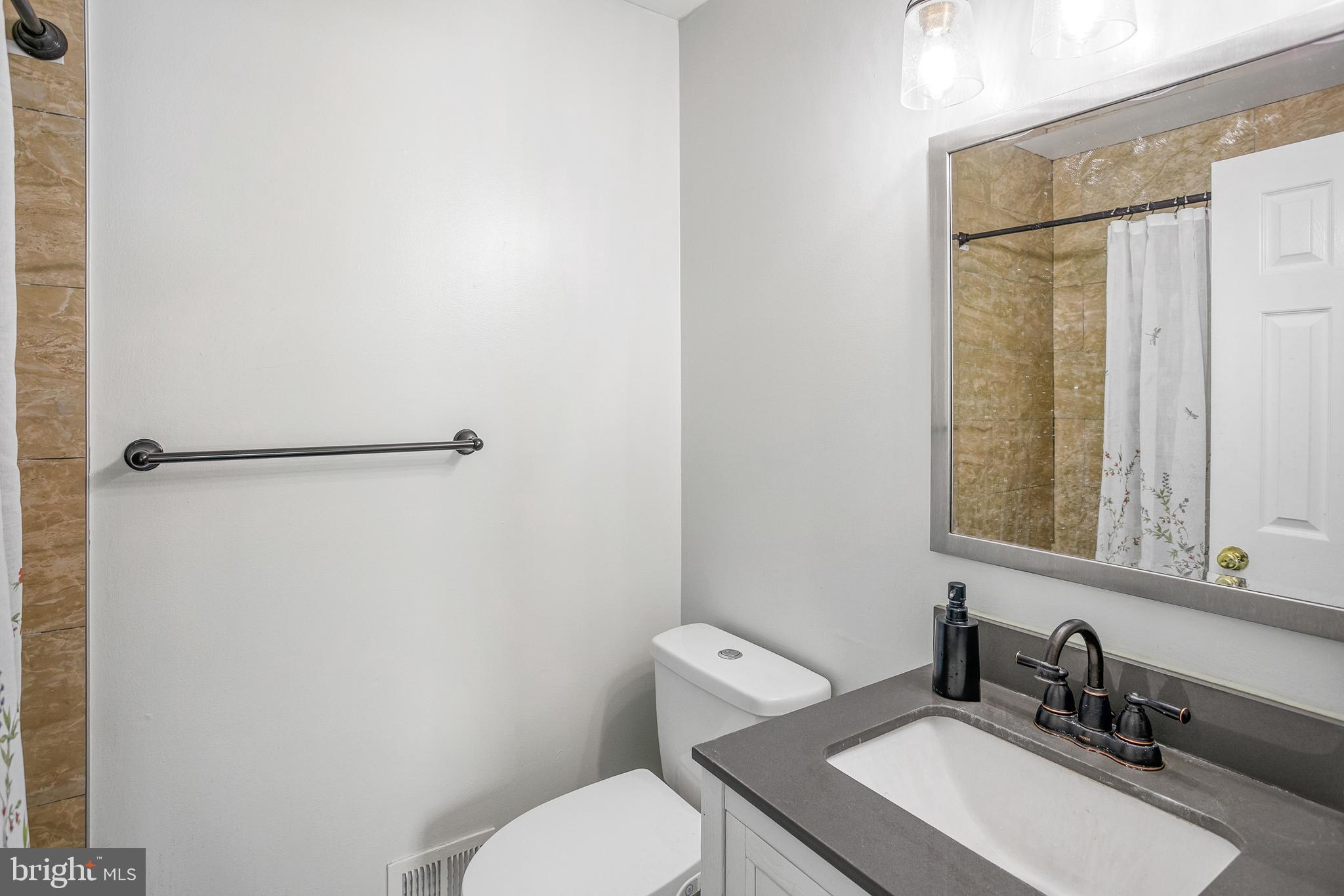 8217 Bayberry Ridge Road Fairfax Station, VA 22039 - Photo 23 of 35 a bathroom with a toilet a sink and a mirror