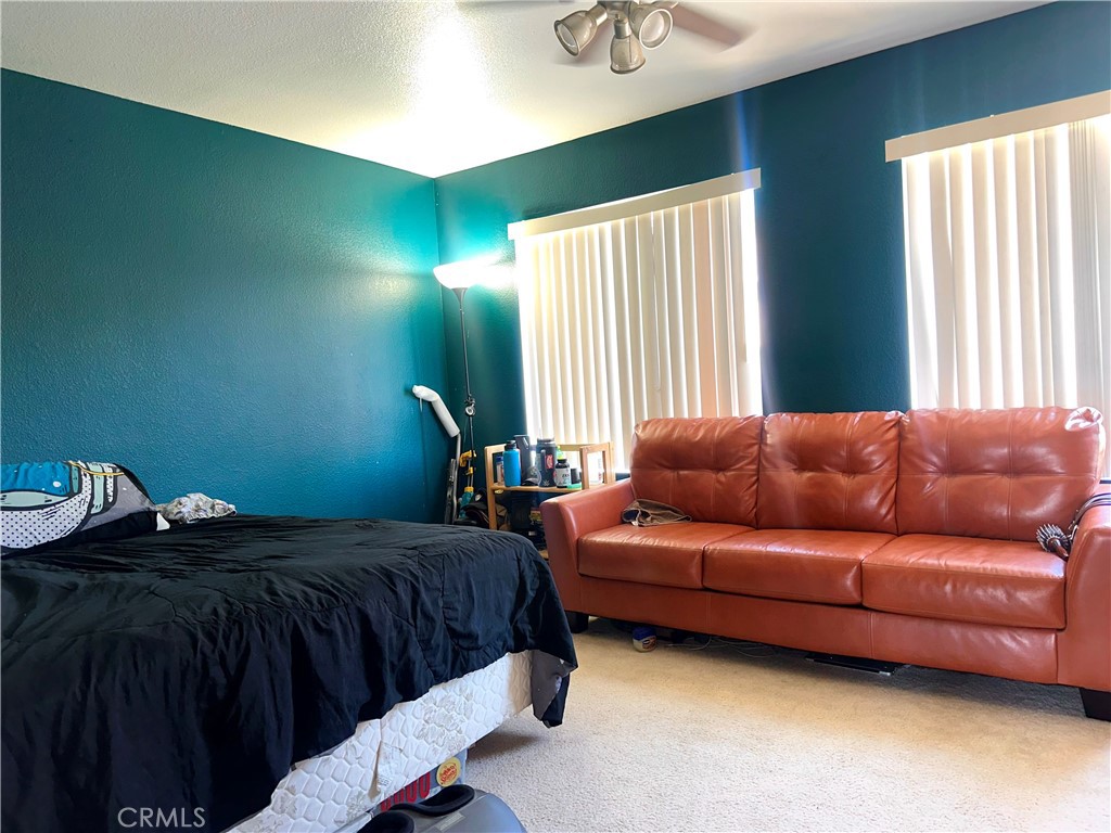 1204 Lilac Ridge Drive Perris, CA 92571 - Photo 13 of 14 a bedroom with a bed couch and window