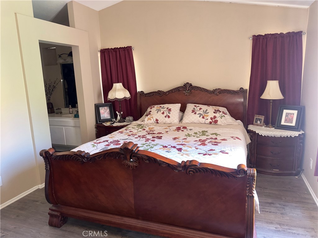 1204 Lilac Ridge Drive Perris, CA 92571 - Photo 8 of 14 a bed sitting in a bedroom next to a wooden floor