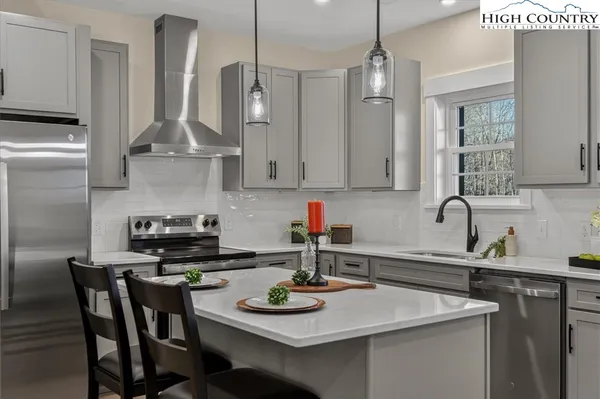 a kitchen with stainless steel appliances a table chairs and cabinets