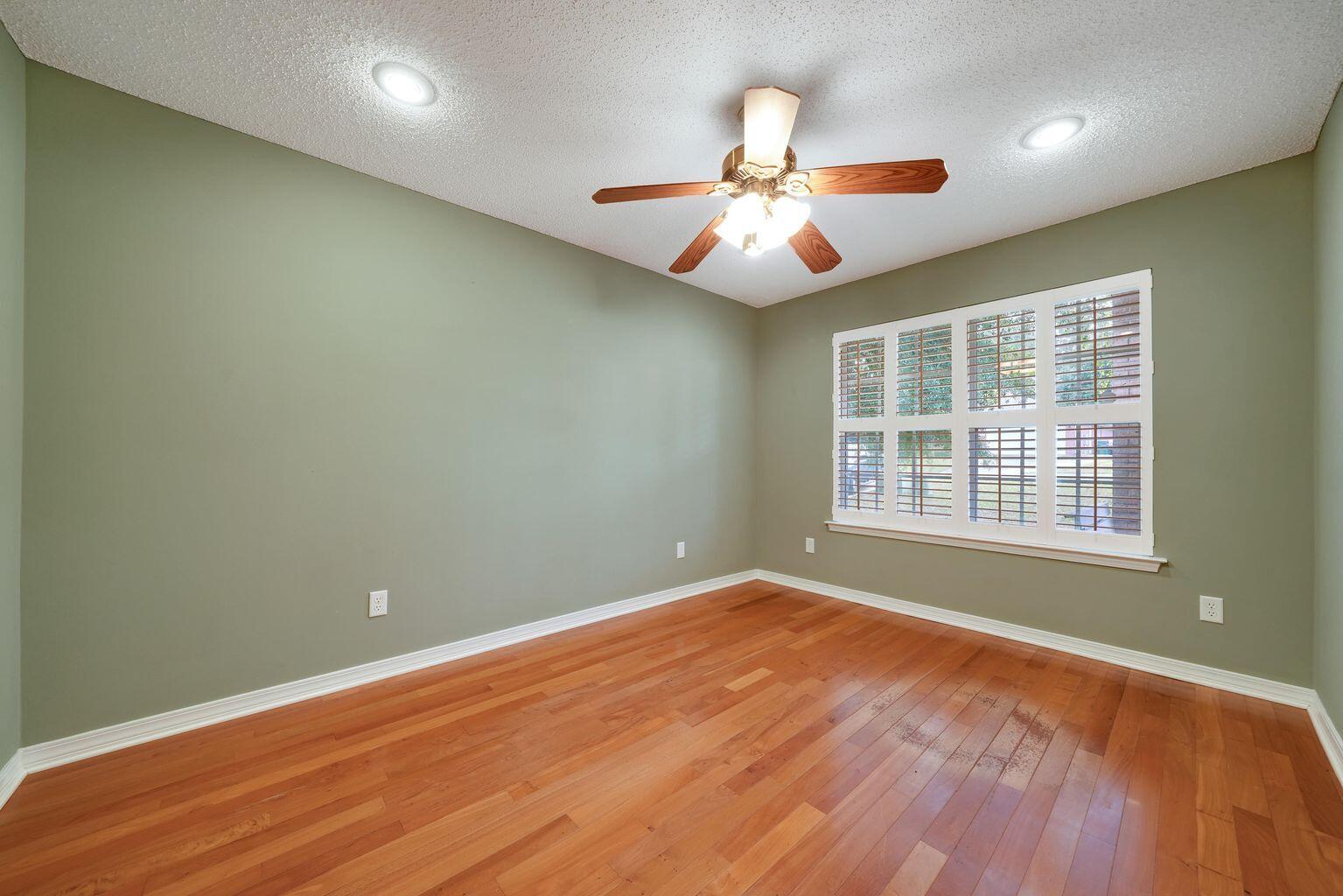 720 Riva Ridge Drive Crestview, FL 32539 - Photo 18 of 36 an empty room with wooden floor fan and windows