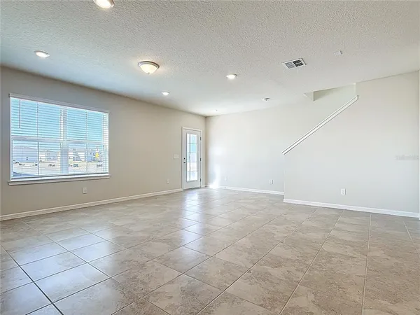 an empty room with windows and cabinet