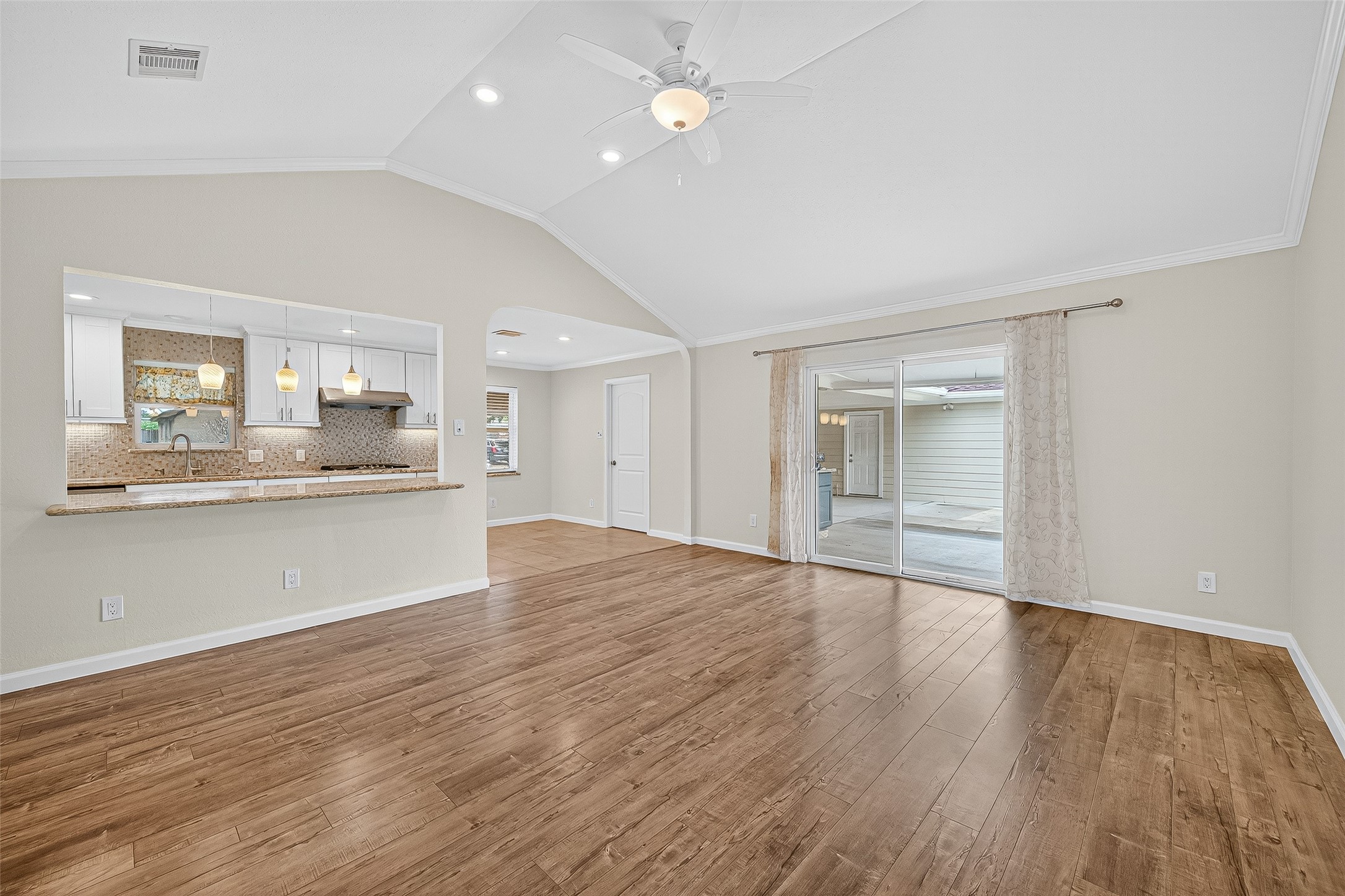 8530 Roos Road Houston, TX 77036 - Photo 15 of 43 a view of an empty room and kitchen with wooden floor