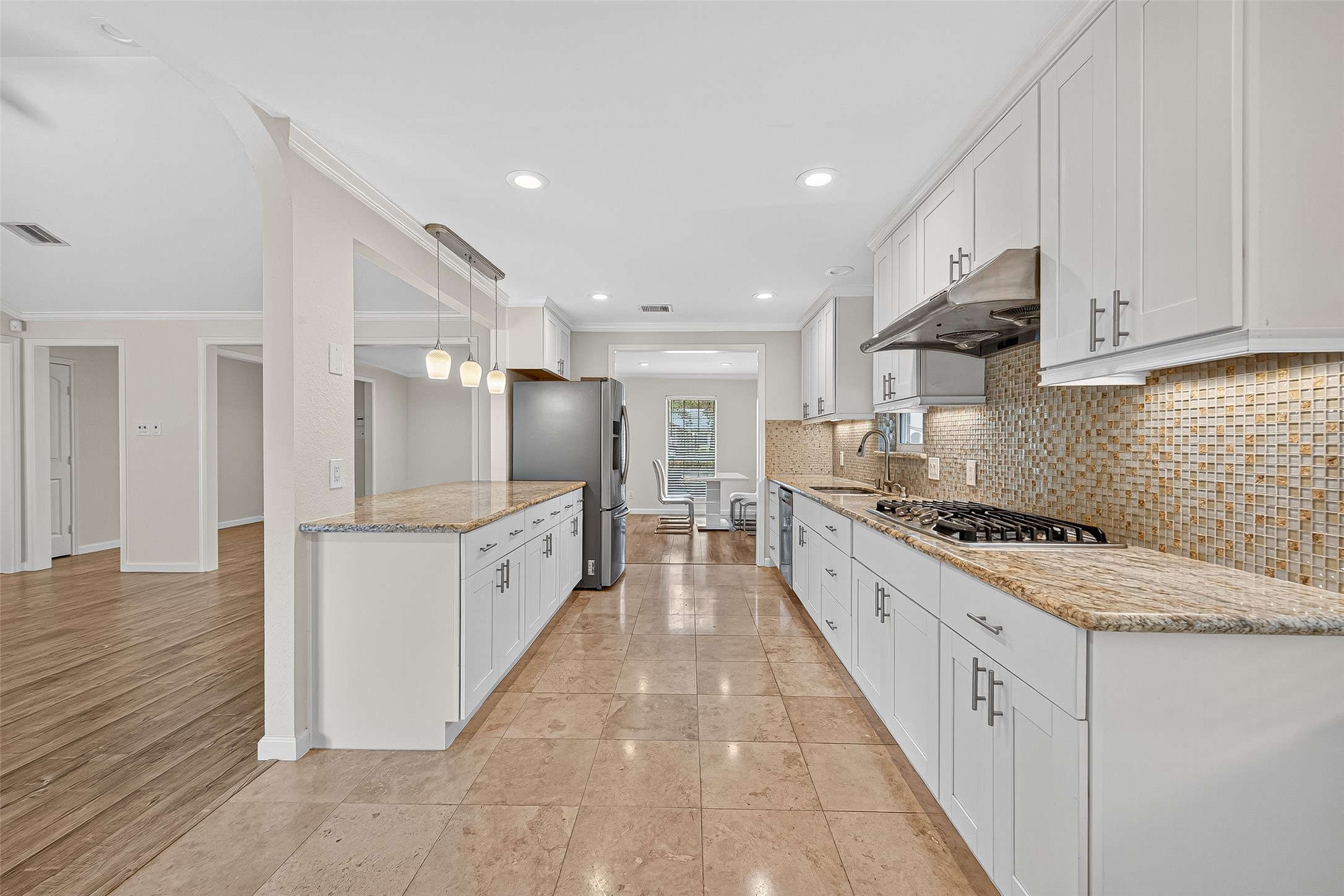 8530 Roos Road Houston, TX 77036 - Photo 22 of 43 a large kitchen with white cabinets stainless steel appliances