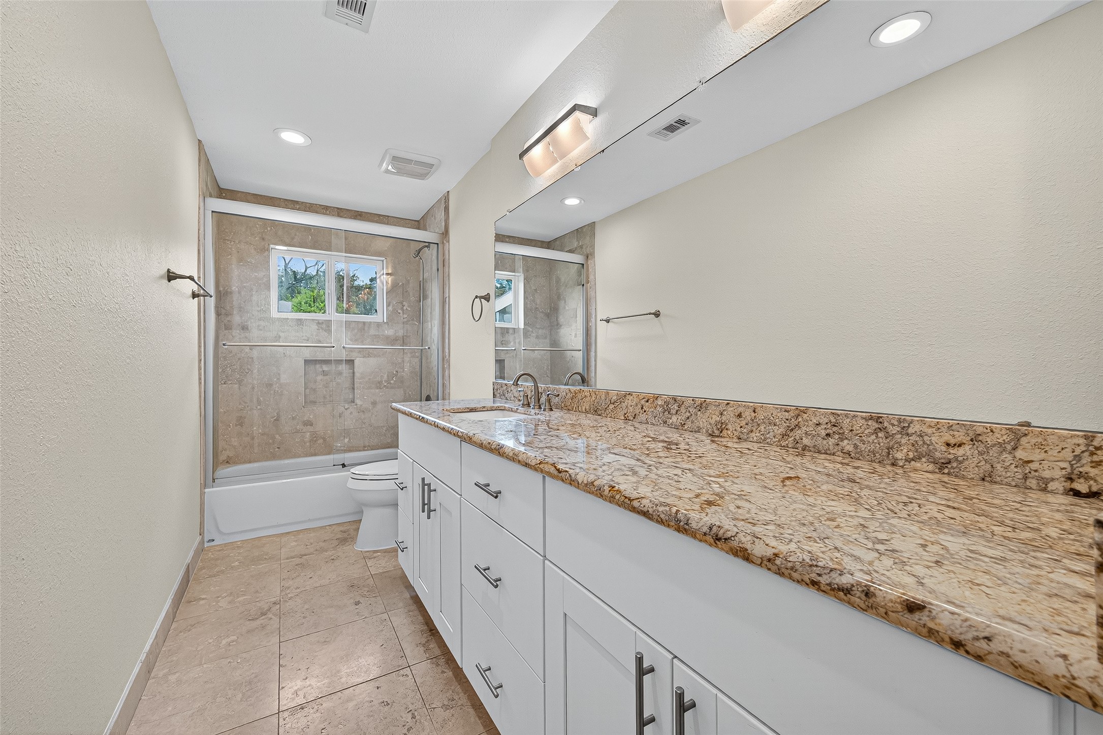 8530 Roos Road Houston, TX 77036 - Photo 31 of 43 a spacious bathroom with a granite countertop sink a toilet and a shower
