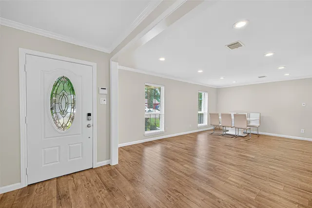 a view of empty room with wooden floor and window