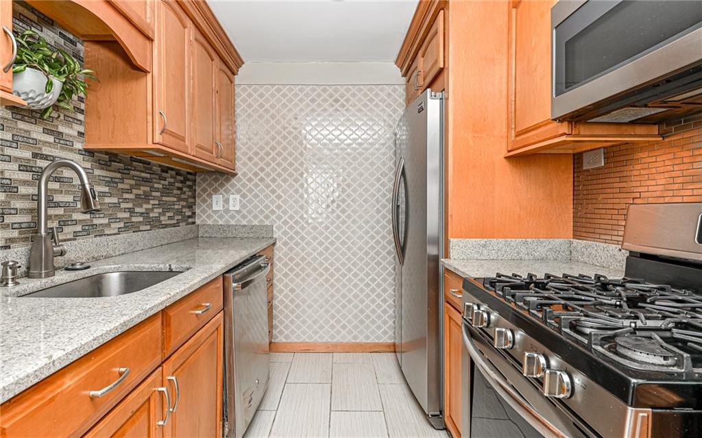 4601 Fifth Avenue, Unit 322 Pittsburgh, PA 15213 - Photo 11 of 18 a kitchen with granite countertop a sink stove and cabinets