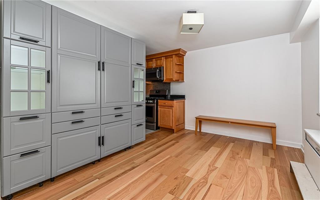 4601 Fifth Avenue, Unit 322 Pittsburgh, PA 15213 - Photo 11 of 27 a kitchen with white cabinets and wooden floor