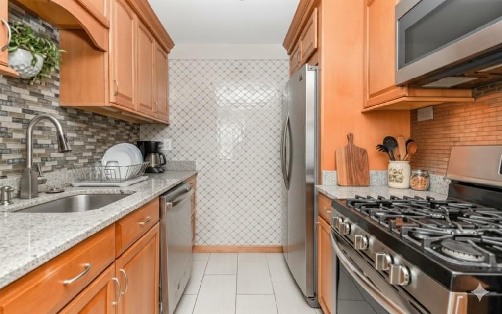 4601 Fifth Avenue, Unit 322 Pittsburgh, PA 15213 - Photo 16 of 27 a kitchen with stainless steel appliances granite countertop a sink stove and refrigerator