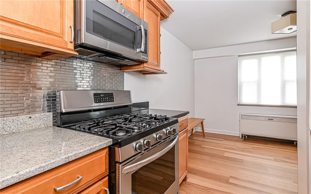 4601 Fifth Avenue, Unit 322 Pittsburgh, PA 15213 - Photo 17 of 27 a kitchen with wooden cabinets and a stove top oven