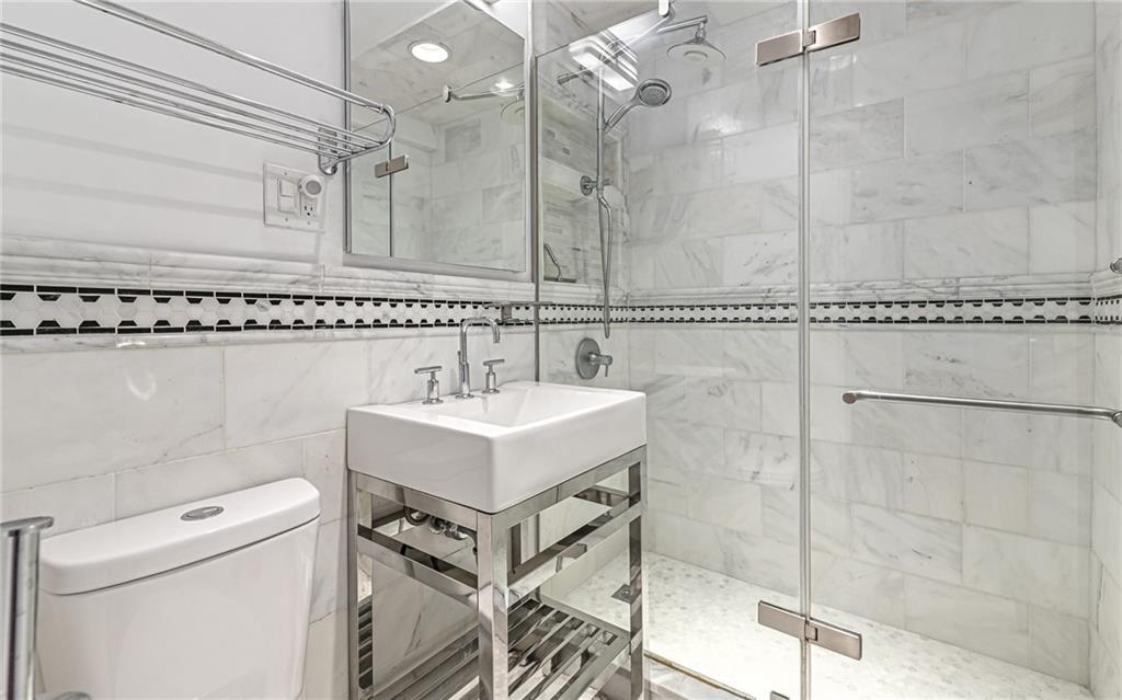 4601 Fifth Avenue, Unit 322 Pittsburgh, PA 15213 - Photo 19 of 27 a bathroom with a sink a toilet and shower