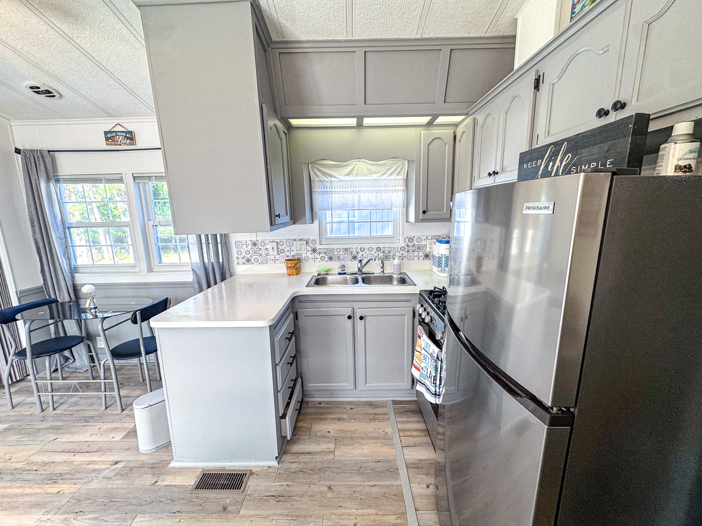4-2 Woodhaven Sublette, IL 61367 - Photo 20 of 27 a kitchen with a refrigerator a stove a sink and a dining table with wooden floor