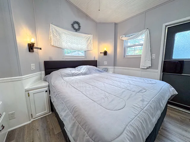 a bedroom with a bed and wooden floor