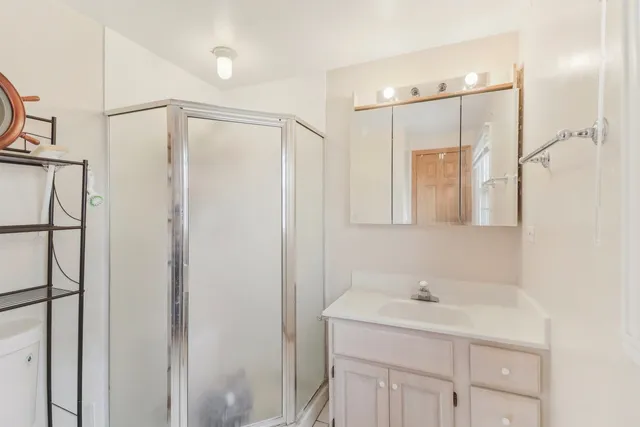 a bathroom with a shower sink vanity and mirror