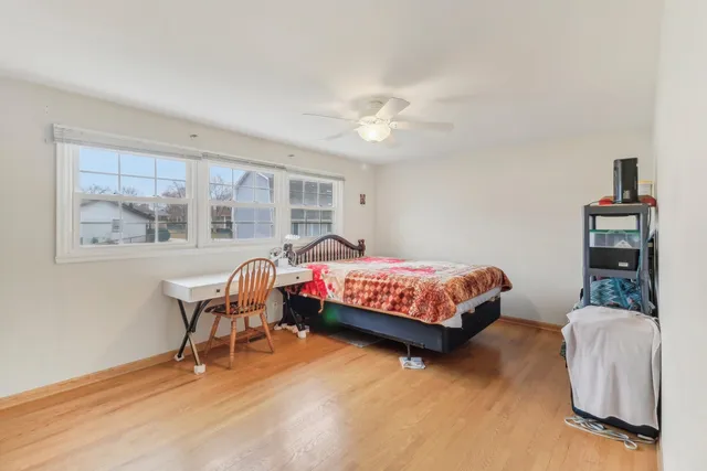a bedroom with a bed wooden floor and a window