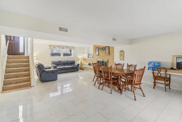 a living room with furniture and a dining table with chairs
