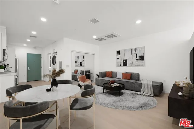 a living room with lots of furniture and view of kitchen