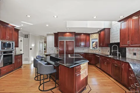 a kitchen with stainless steel appliances granite countertop a sink stove and refrigerator