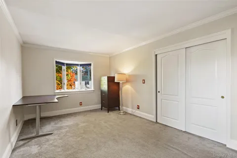 a view of an empty room with window and cabinet