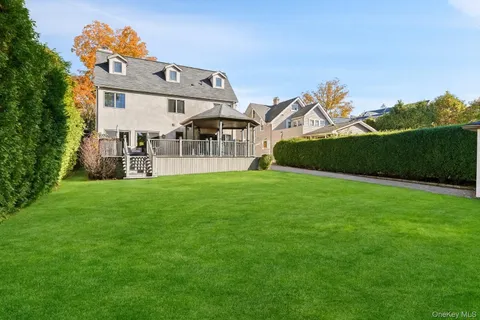 a view of a house with a big yard and large trees