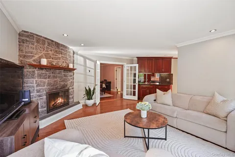 a living room with furniture a fireplace and a large mirror