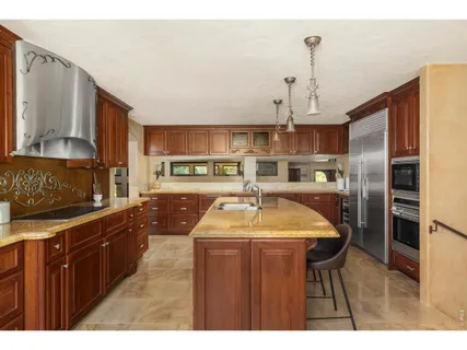 a kitchen with stainless steel appliances granite countertop a sink and a refrigerator