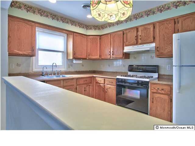 54 Oakfield Road Toms River, NJ 08757 - Photo 14 of 25 a kitchen with kitchen island granite countertop a sink stainless steel appliances and cabinets