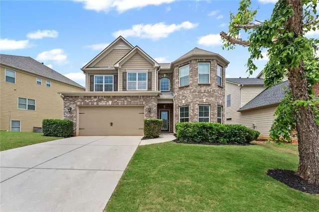 a front view of a house with a yard and garage