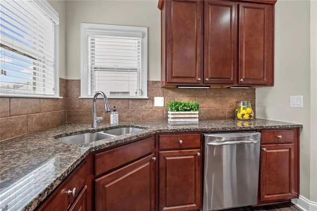 a kitchen with granite countertop cabinets sink and window