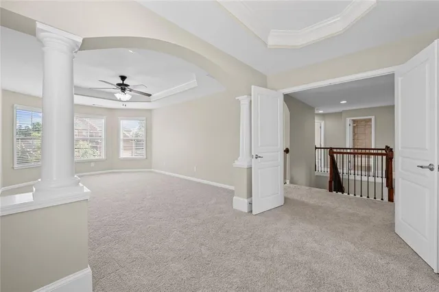 an empty room with windows and ceiling fan