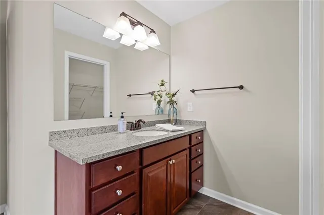 a bathroom with a granite countertop sink and a mirror