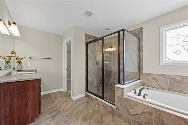 a bathroom with a tub a sink and mirror