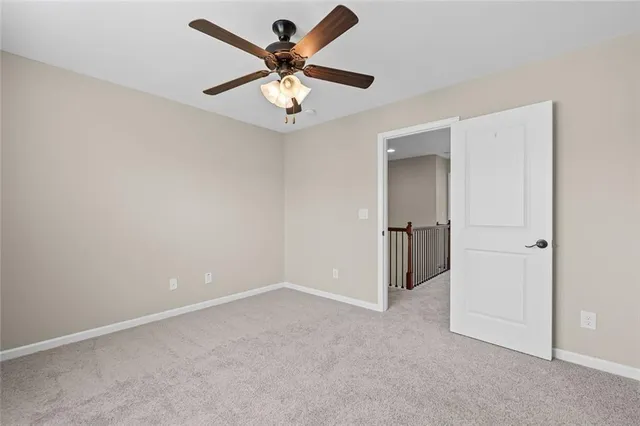 an empty room with closet and a ceiling fan