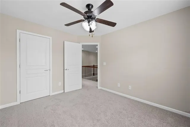 an empty room with a ceiling fan and a window