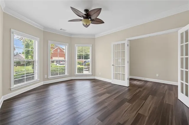 a view of wooden floor and a chandelier fan in a room