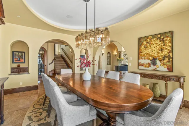 a dining room with chandelier and wooden floor