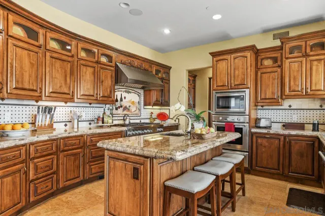 a kitchen with stainless steel appliances granite countertop a stove top oven a sink dishwasher and cabinets with wooden cabinets