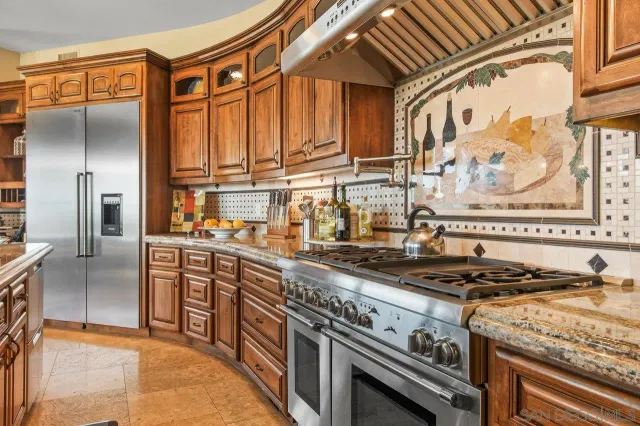a kitchen with stainless steel appliances granite countertop a stove and a refrigerator