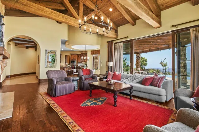 a living room with furniture a rug and a floor to ceiling window