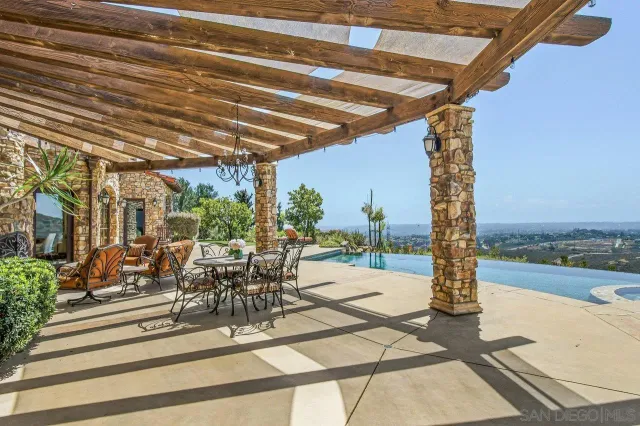 a view of a patio with a dining table and chairs with wooden floor
