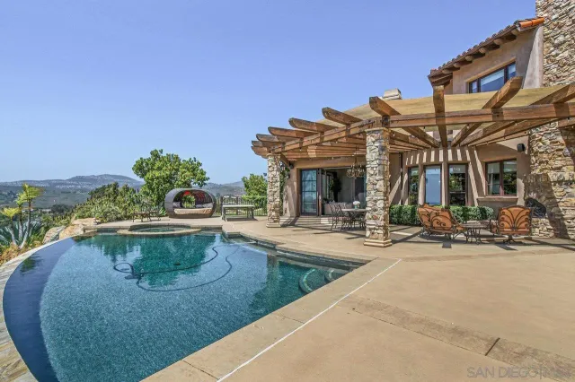 a view of a house with sitting area and swimming pool