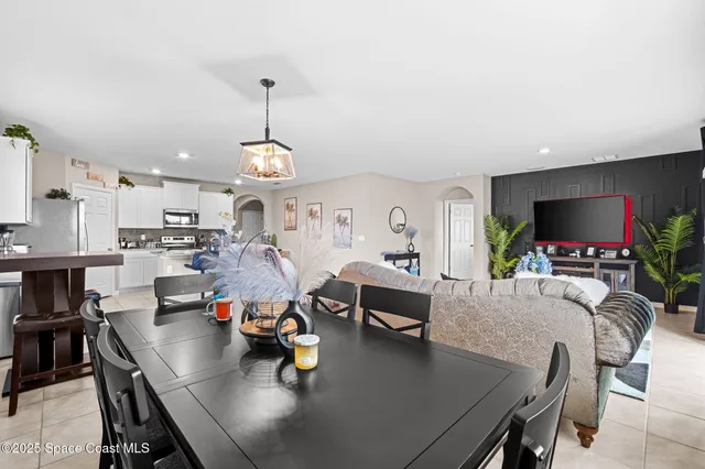 a living room with furniture a flat screen tv and kitchen view