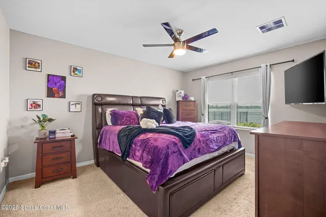 a bed sitting in a bedroom next to a window