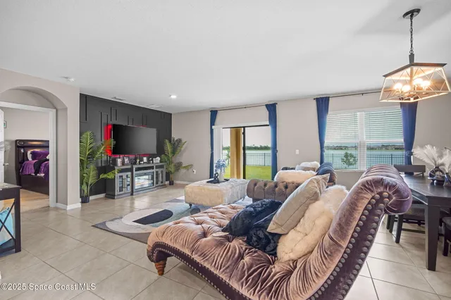 a living room with furniture a large window and a flat screen tv