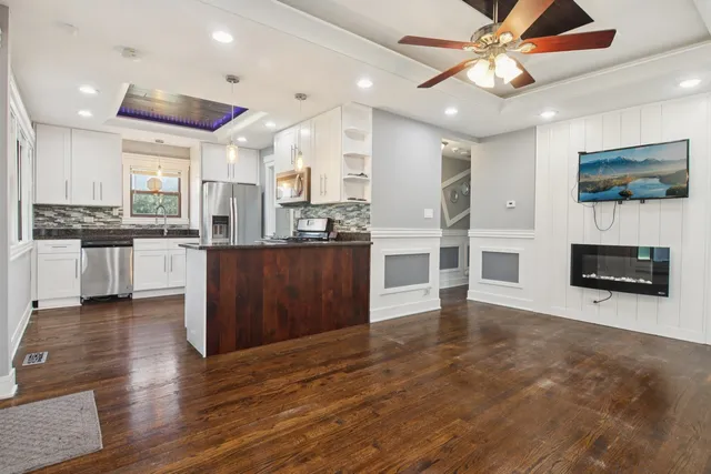 an open kitchen with kitchen island and stainless steel appliances