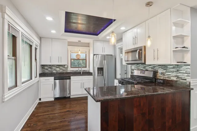 a kitchen with stainless steel appliances granite countertop a refrigerator a stove microwave and cabinets