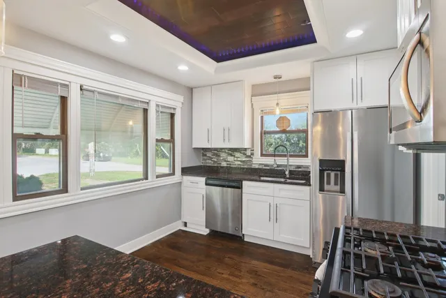 a kitchen with stainless steel appliances granite countertop a refrigerator and a stove