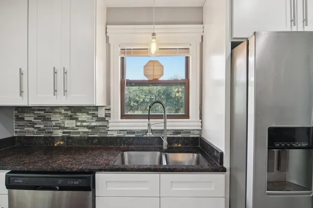a kitchen with stainless steel appliances granite countertop a refrigerator and a sink